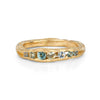 An irregular channel forms a valley of solid band of 18ct yellow gold, natural sapphires nestling in the sea worn crease. By Emily Nixon.