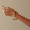 Unique craggy bangle stack in gold on model