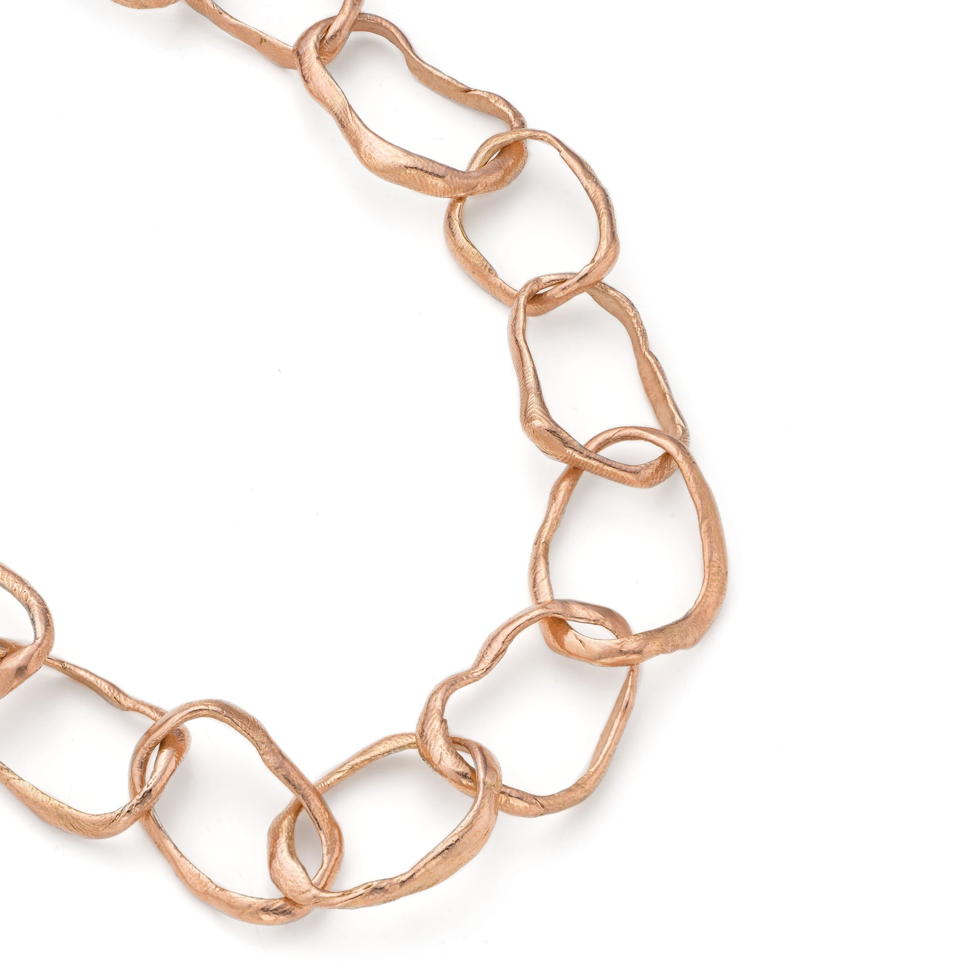 Detail of the hand crafted, irregular, solid rose gold links that make up the chain in Emily Nixon's Stone Drawing Necklace. Each link has been handmade to be different. The gold chain links retain a lustre without being overly shiny. Tactile and utterly wearable, a relaxed gold necklace to put on everyday by Cornwall jewellery designer Emily Nixon..
