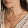 Contemporary jewellery necklace designed by Cornish jeweller Emily Nixon. Fine - approx 1cm across - irregular gold links are interconnected to create a long gold link chain. The style of Emily’s coastal jewellery is artful, organic and distinctly handmade. The links have been formed from small smoothed pebbles from Cornwall’s beaches creating the unusual, natural character of the necklace. Can be worn at long choker length 52cm or a medium length chain at 62cm. 