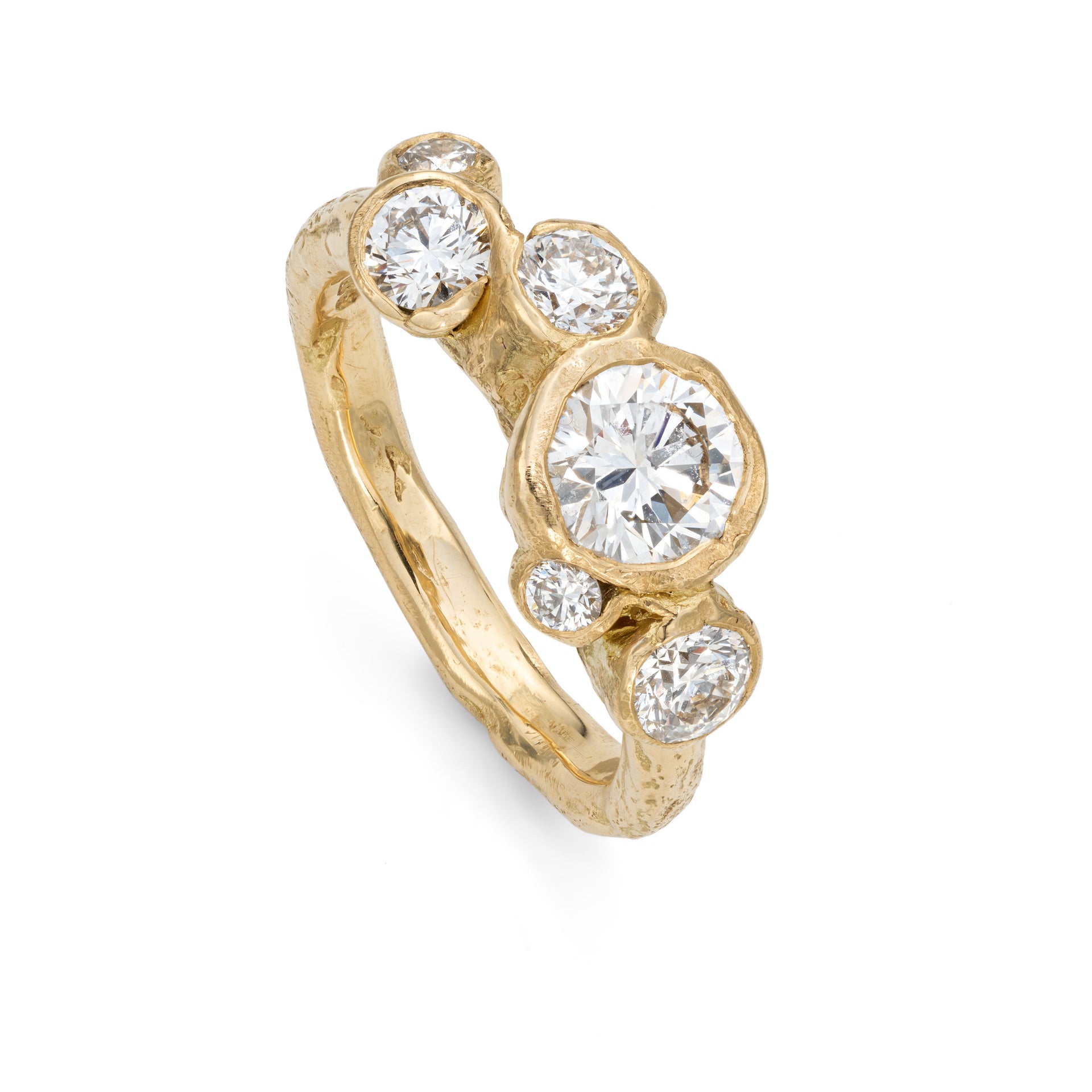 Upright, front view of a beach textured, unusual engagement ring, set with six diamonds. Handcrafted by Emily Nixon.