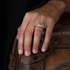 An alternative, sea worn textured engagement ring, set with six diamonds. Photographed on a models hand.