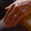 An organic designed, 18ct gold engagement ring, set with six diamonds. Photographed on a models hand.