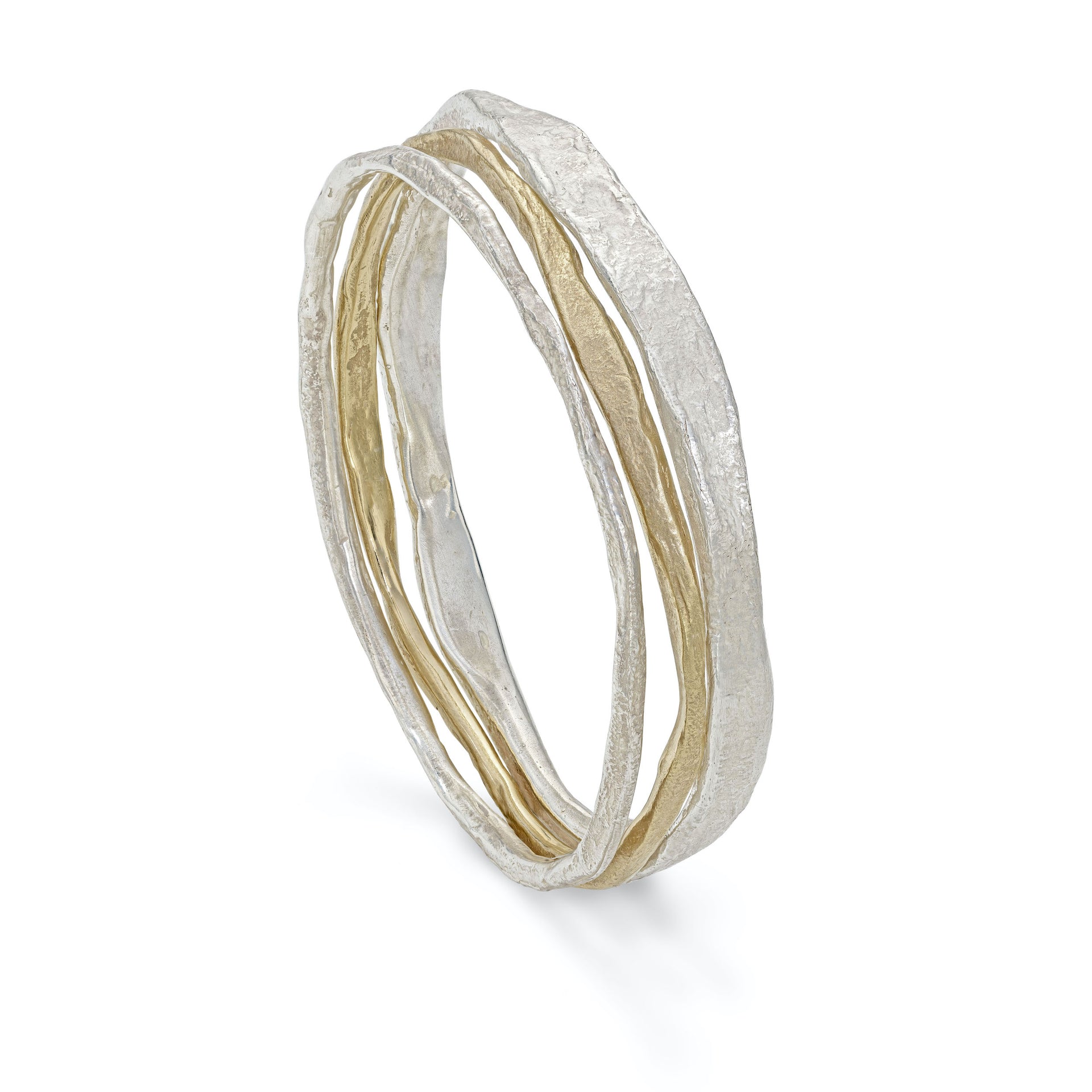 Stacking bangles in solid silver and gold. Chunky, irregular bangles in uneven widths have an organic texture and coastal character. Made in Cornwall.  