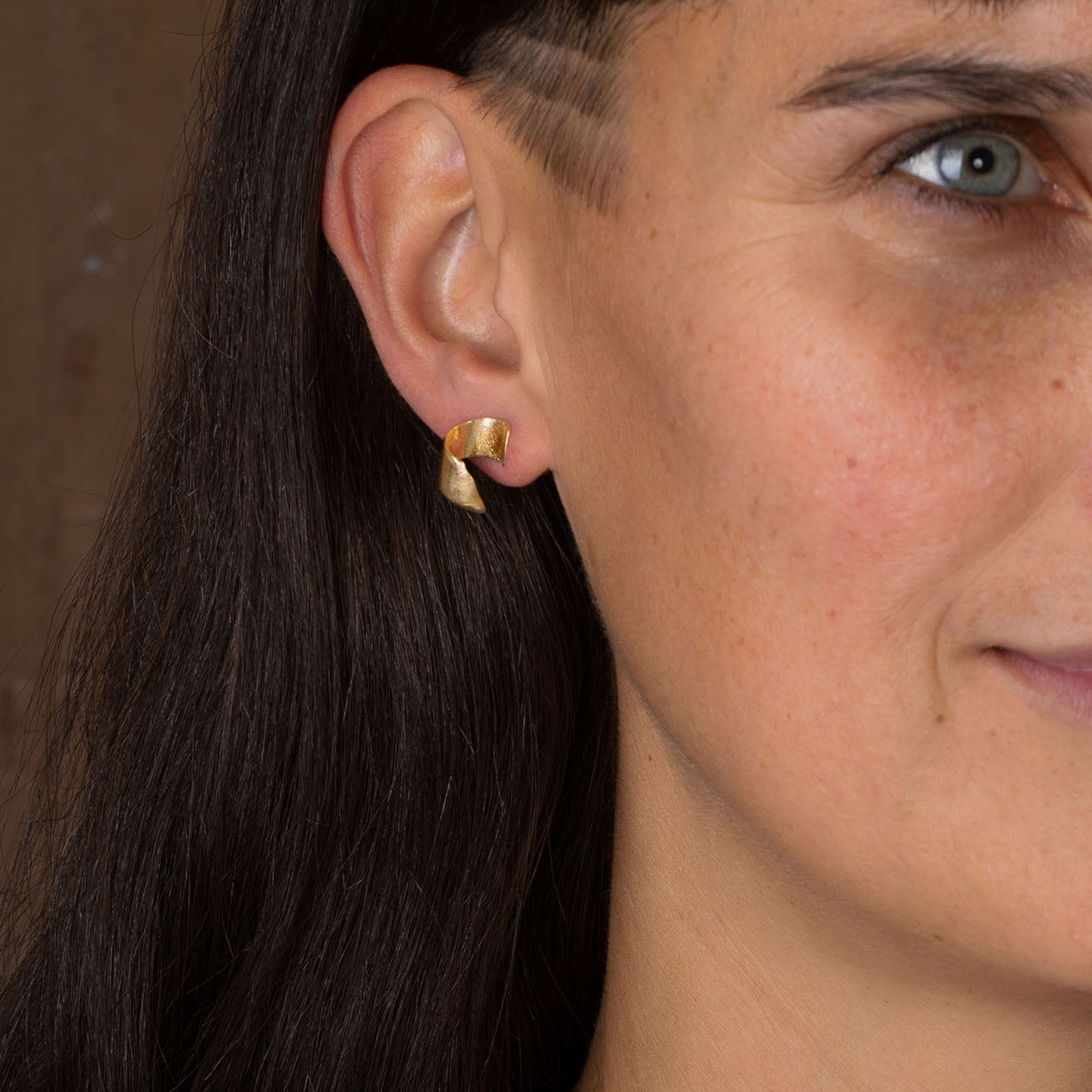 Close up of furl gold earrings by Emily Nixon