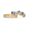 A cornflower blue sapphire ring sat with a diamond eternity ring.