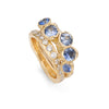 An organic sapphire gemstone ring sat with an unusual diamond eternity ring.