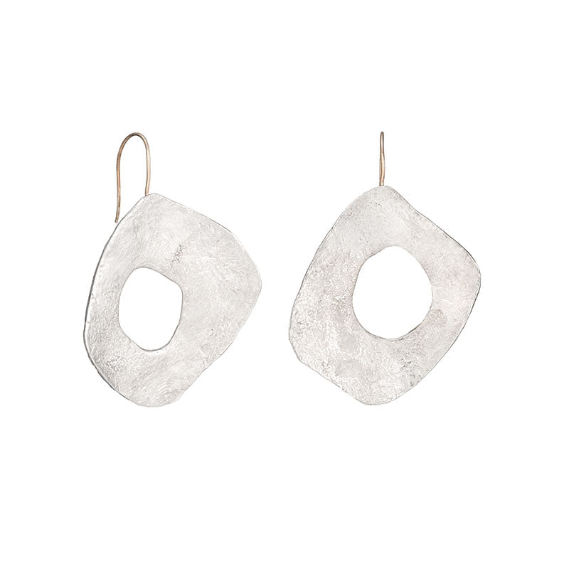 Large statement solid silver drop earrings. Unusual handmade design with stone-like textured surface with a hole through the centre. Handmade by Cornwall designer Emily Nixon.