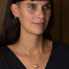 Model wearing furl gold earrings by Emily Nixon