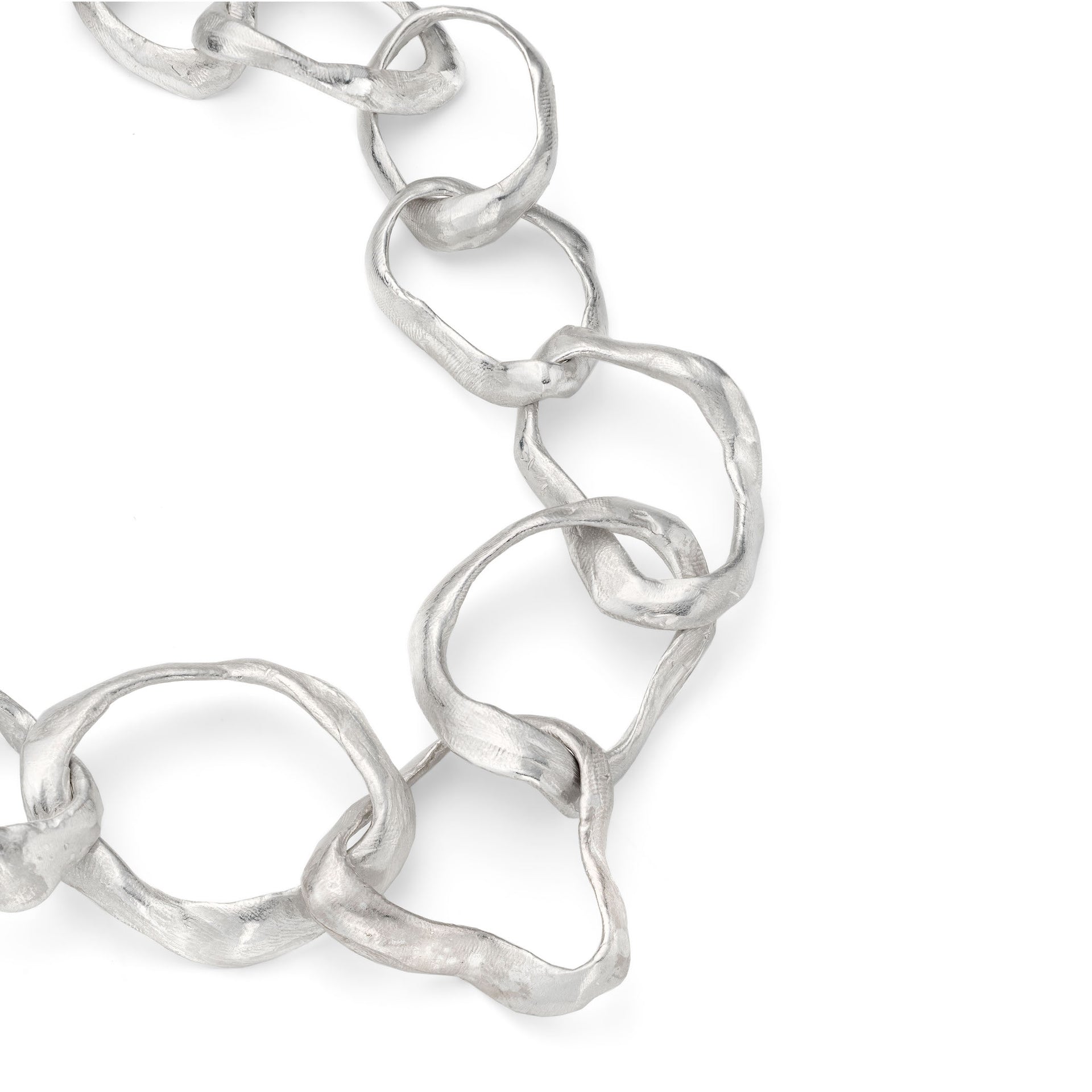 Detail of Emily Nixon’s classic Rock Drawing chunky link silver necklace. Each link has been handmade to have a tumbled, sea worn character. The tools of her jewellery making process - stones, pebbles and rocks - are pressed into the very surface to create the raw, made by hand finish she is known for. Organic and intrinsically coastal jewellery handmade in Emily’s studio on the outskirts of St Ives and cast just 5 miles south near Penzance. A truly locally crafted piece of contemporary jewellery design. 