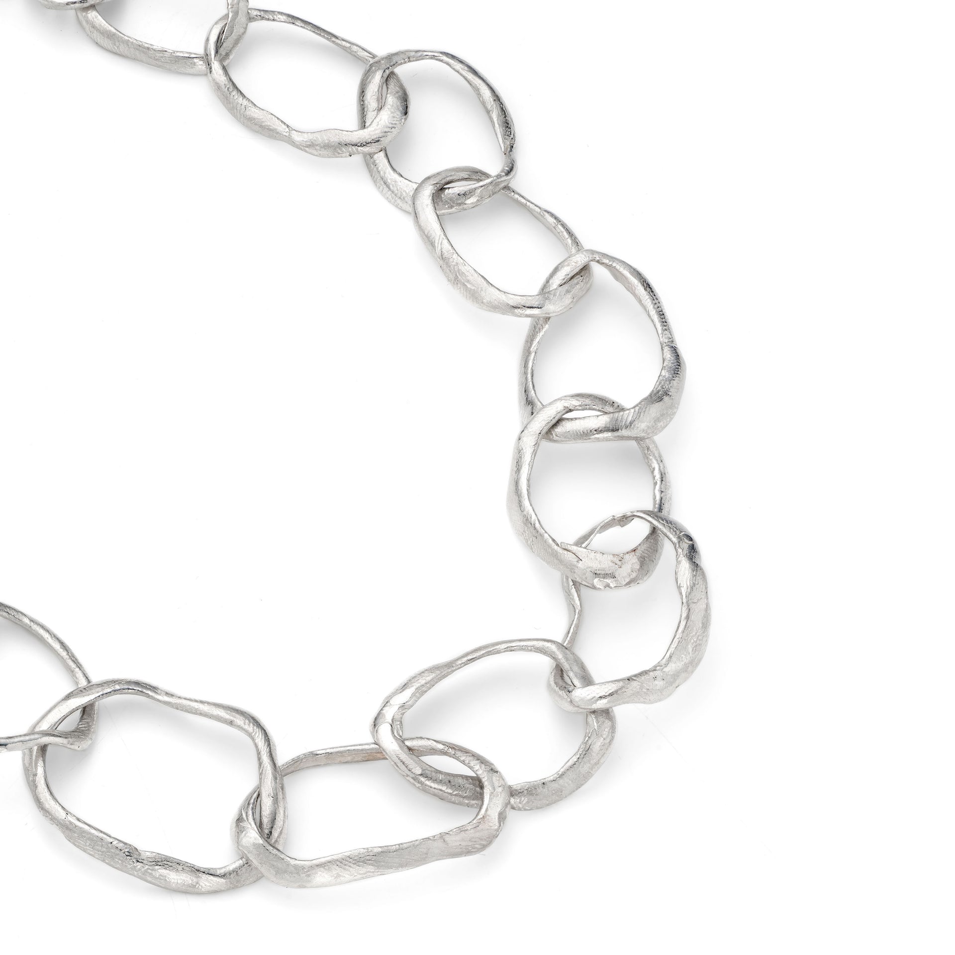 Close up detail of the hand crafted, irregular, solid silver links that make up the chain in Emily Nixon's Stone Drawing Necklace. Each link has been handmade to be different. The sterling silver retains a lustre without being overly shiny. Emily’s signature sea worn finish gives the impression of sea tumbled treasure, jewellery handmade in Cornwall, made tactile by the tide. 
