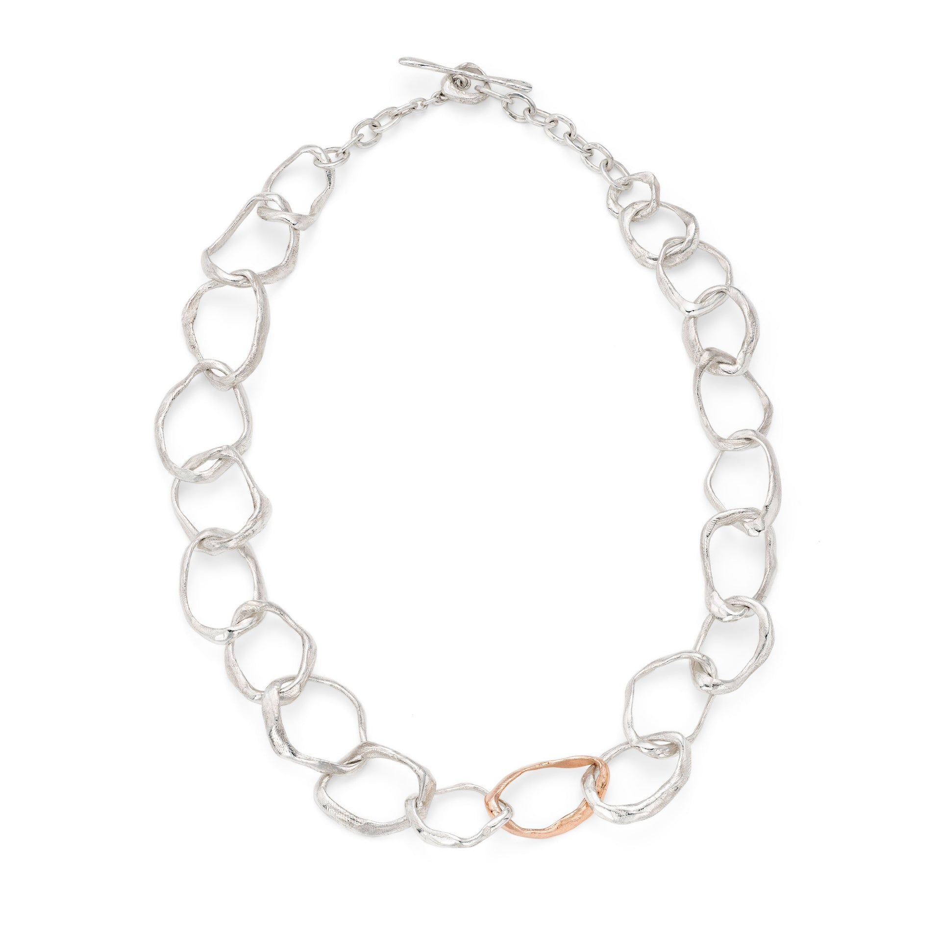 Unusual contemporary jewellery necklace. Irregular silver and rose gold links have been handmade to vary in size and shape creating an uneven chain characteristic of Emily Nixon’s organic sculptural designs. The finish is irresistibly tactile; a gently matte, smoothed surface resembling polished stones. Jewellery handmade in Cornwall, made tactile by the tide. 