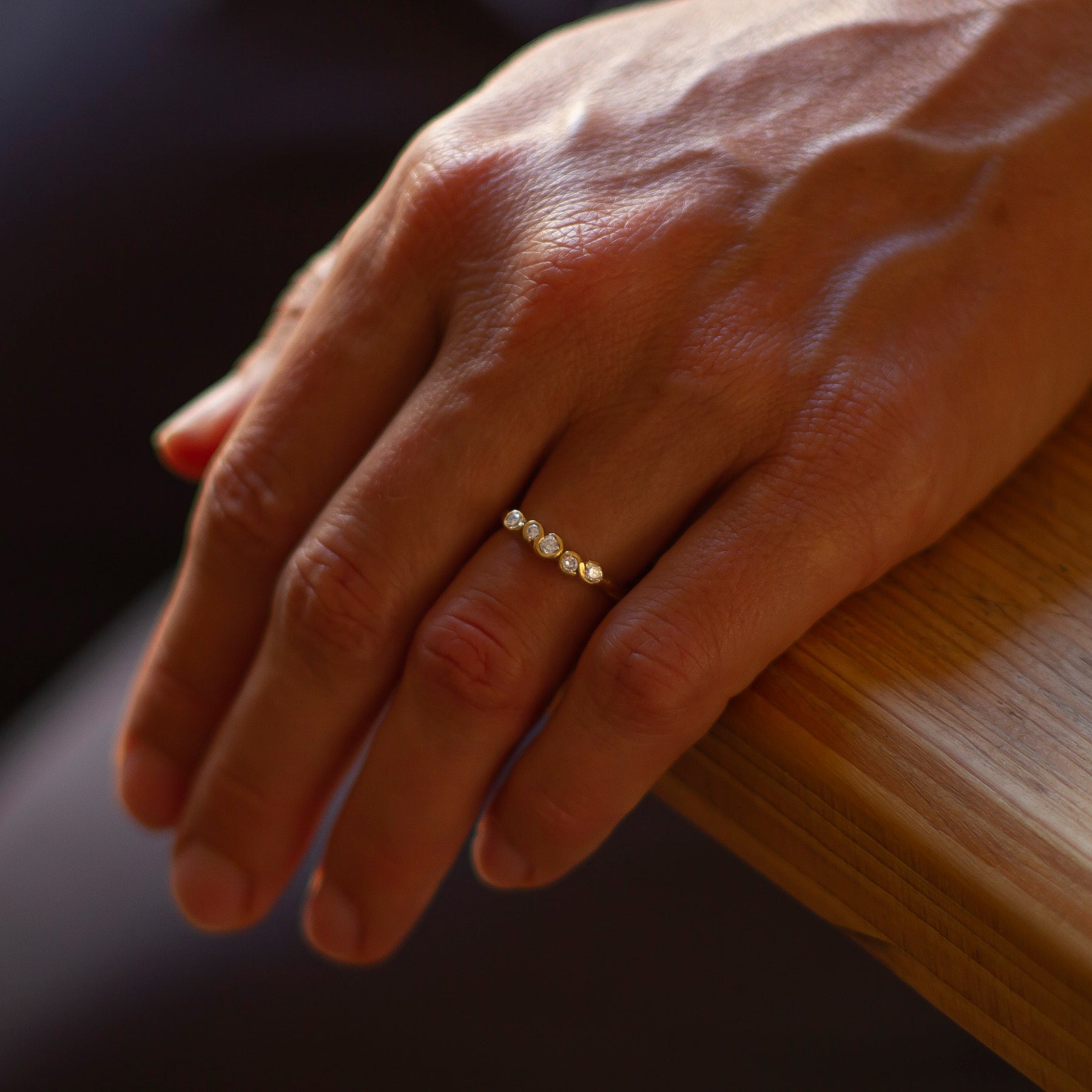 An 18ct gold and diamond engagement ring, handcrafted by Emily Nixon and photographed on a models hand.